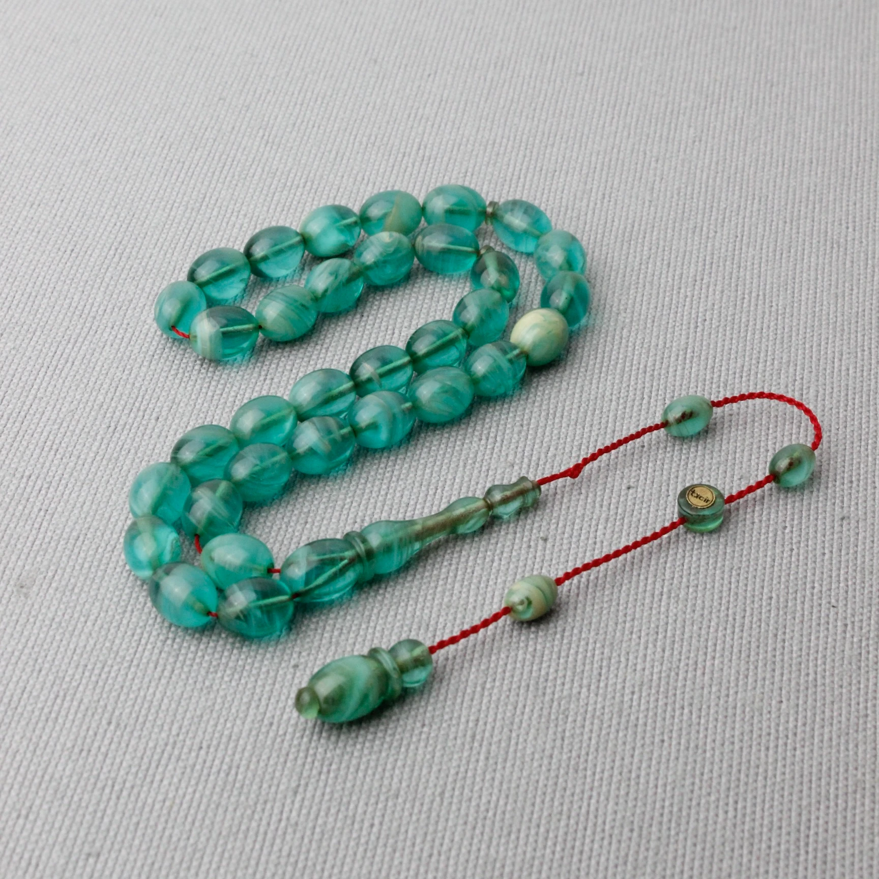 Hareli Turkuaz Renk Tacir İmzalı Sıkma Kehribar Tespih