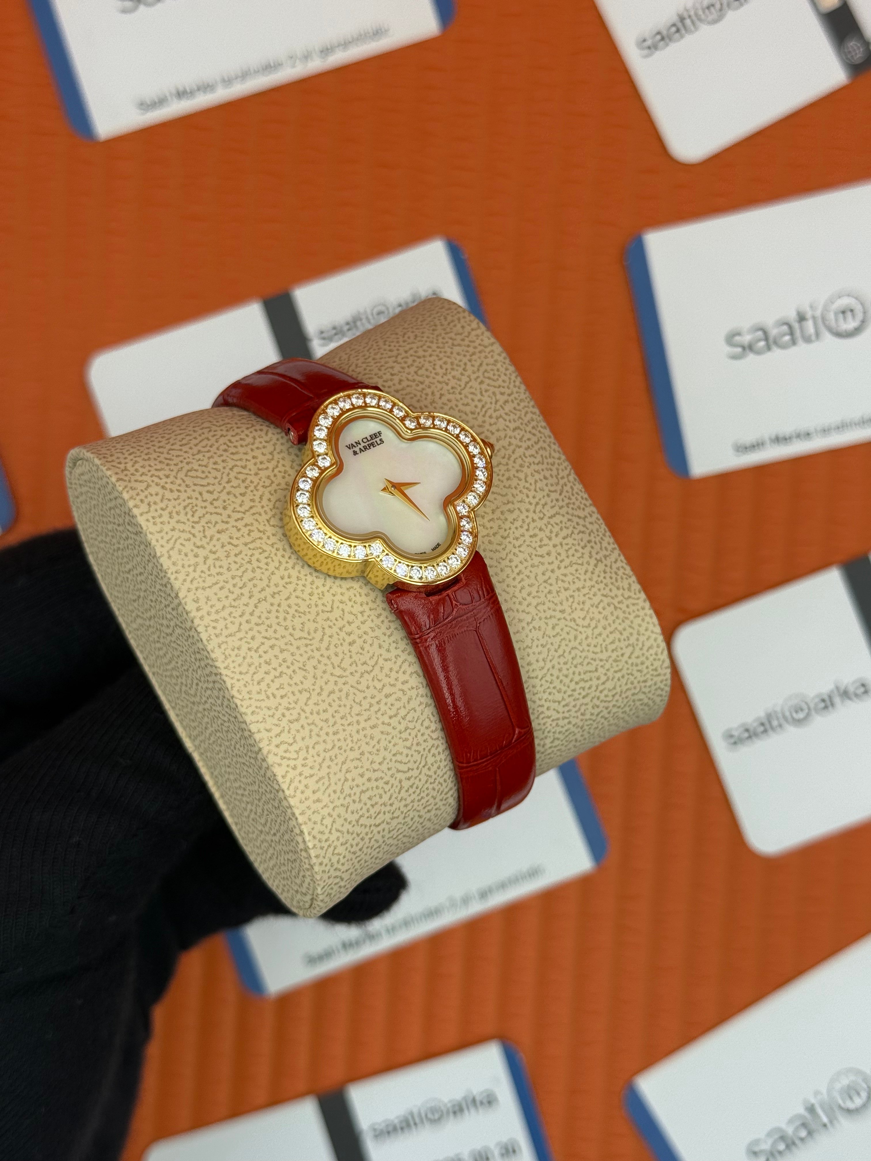 VAN CLEEF beyaz kadran kırmızı deri kordon gold kasa taşlı bezel kadın kol saati