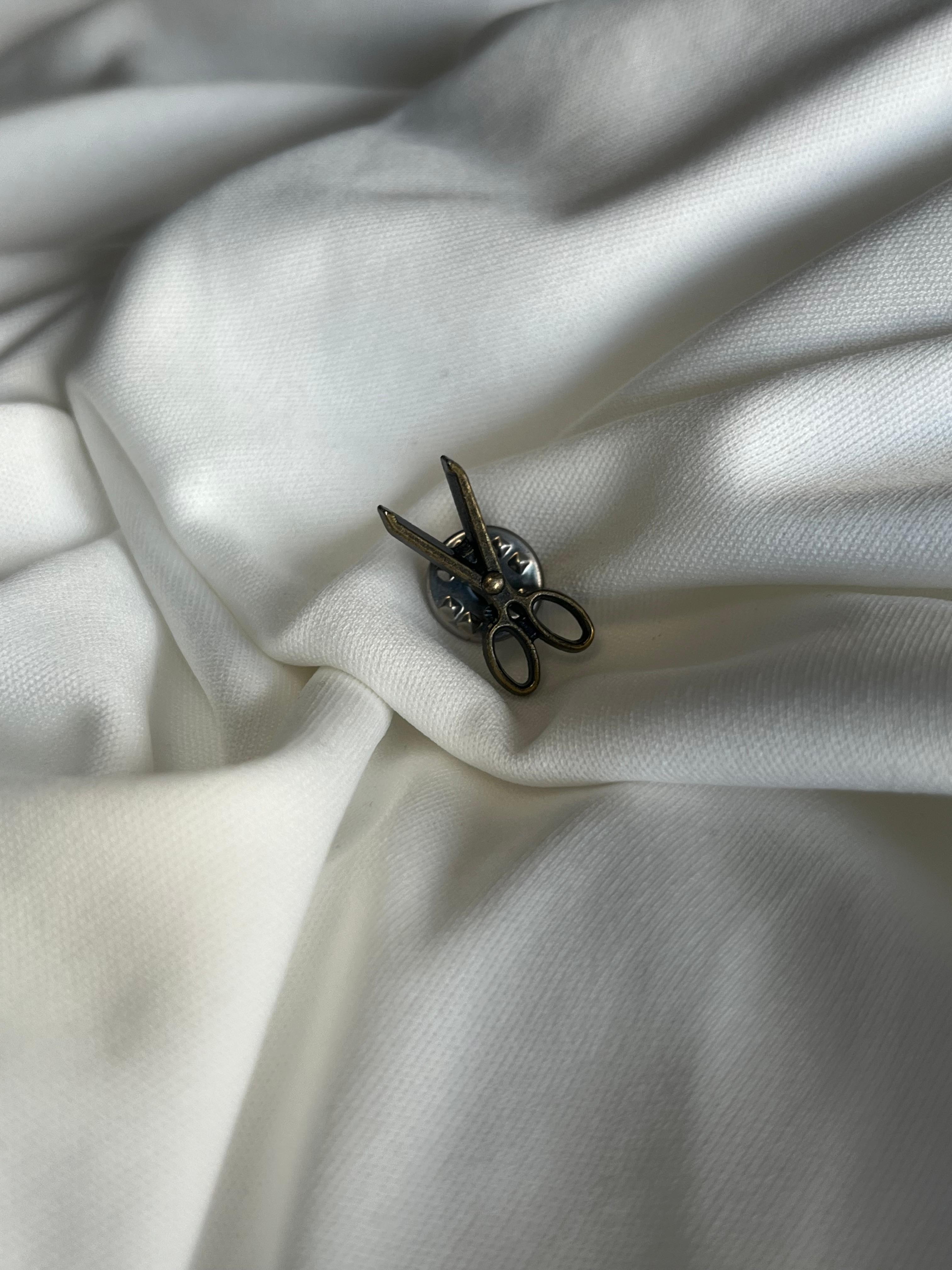 Tiny lapel brooch.