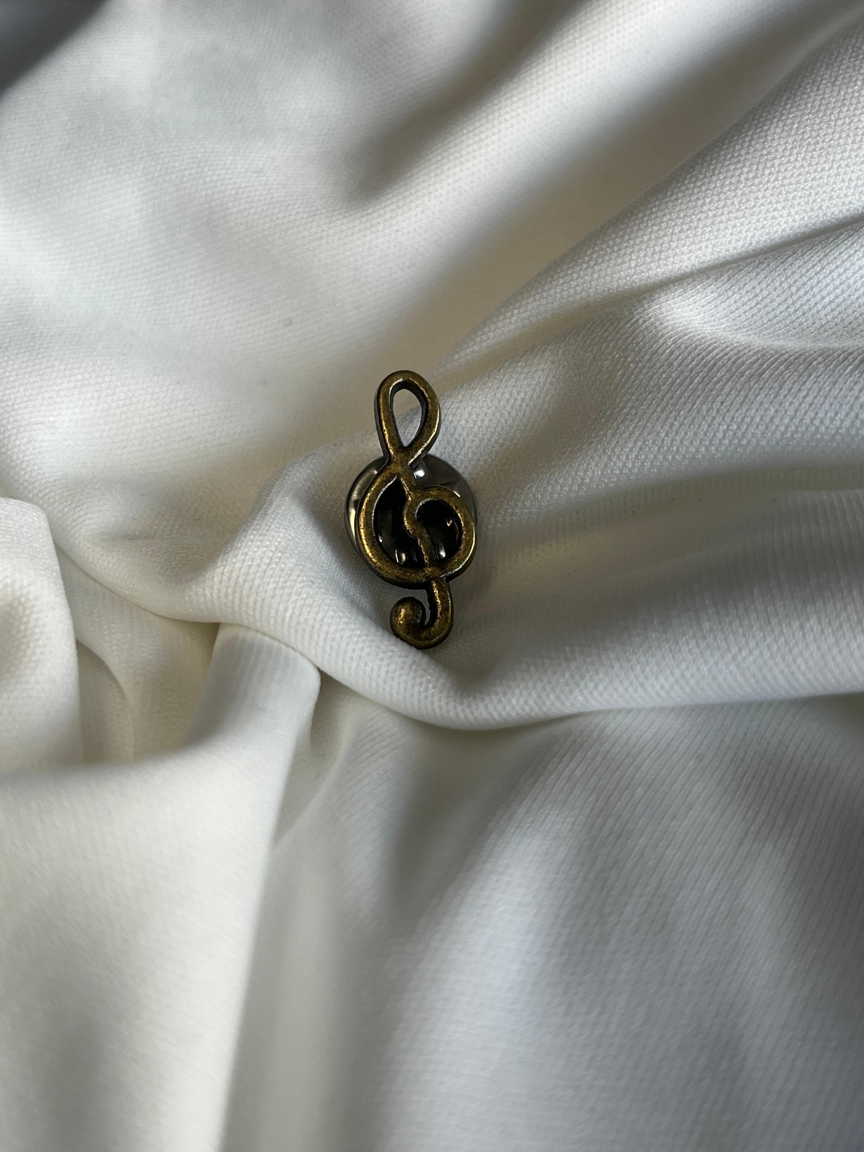 Tiny lapel brooch.