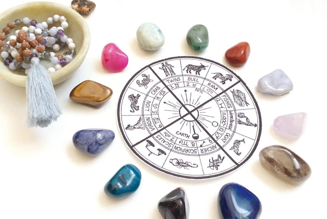 “Burç simgeleriyle çevrelenmiş doğal taşlar ve mala kolyesi; astroloji ve enerjisel taşlar arasındaki ilişkiyi temsil ediyor.”