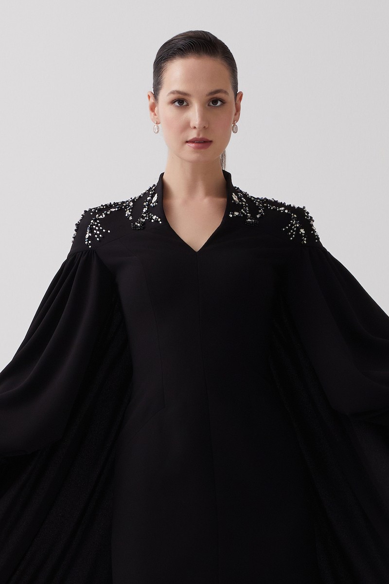 R106 - High V-Neckline, Yoke, Padded Shoulders, Cuffed Sleeves, Batwing Cape, Hand-Embroidered Shoulder Details, Back Slit, Straight Cut, Full-Length Dress