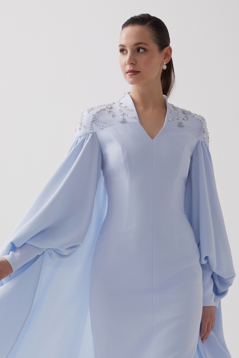 R106 - High V-Neckline, Yoke, Padded Shoulders, Cuffed Sleeves, Batwing Cape, Hand-Embroidered Shoulder Details, Back Slit, Straight Cut, Full-Length Dress