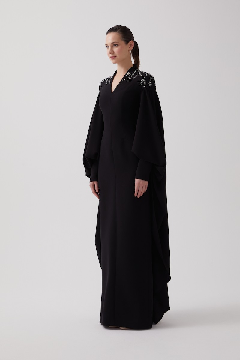 R106 - High V-Neckline, Yoke, Padded Shoulders, Cuffed Sleeves, Batwing Cape, Hand-Embroidered Shoulder Details, Back Slit, Straight Cut, Full-Length Dress