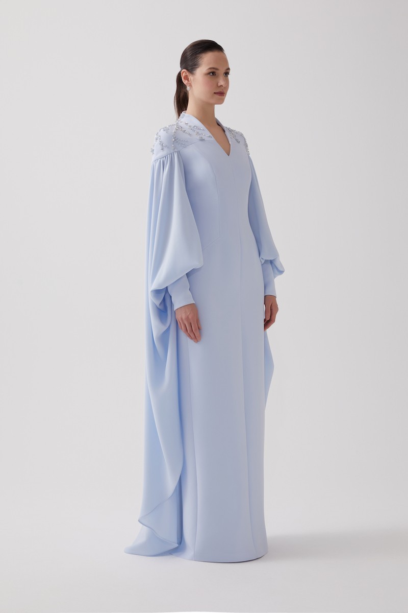 R106 - High V-Neckline, Yoke, Padded Shoulders, Cuffed Sleeves, Batwing Cape, Hand-Embroidered Shoulder Details, Back Slit, Straight Cut, Full-Length Dress