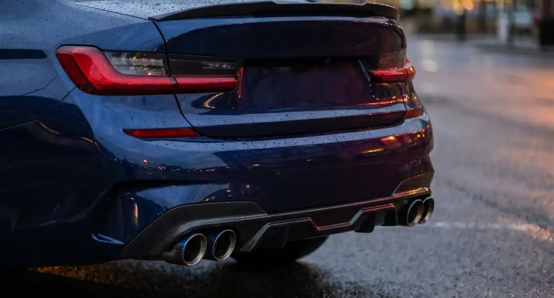 A carbon rear diffuser and quad exhaust tips — with a small carbon boot-lip spoiler above.