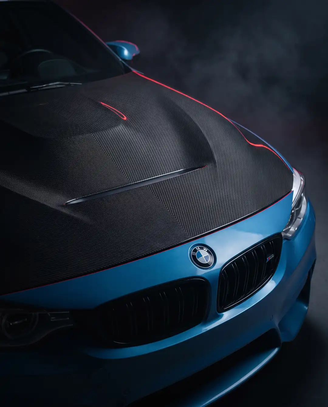 The carbon hood takes weight from the car’s highest point; the vents help manage heat.
