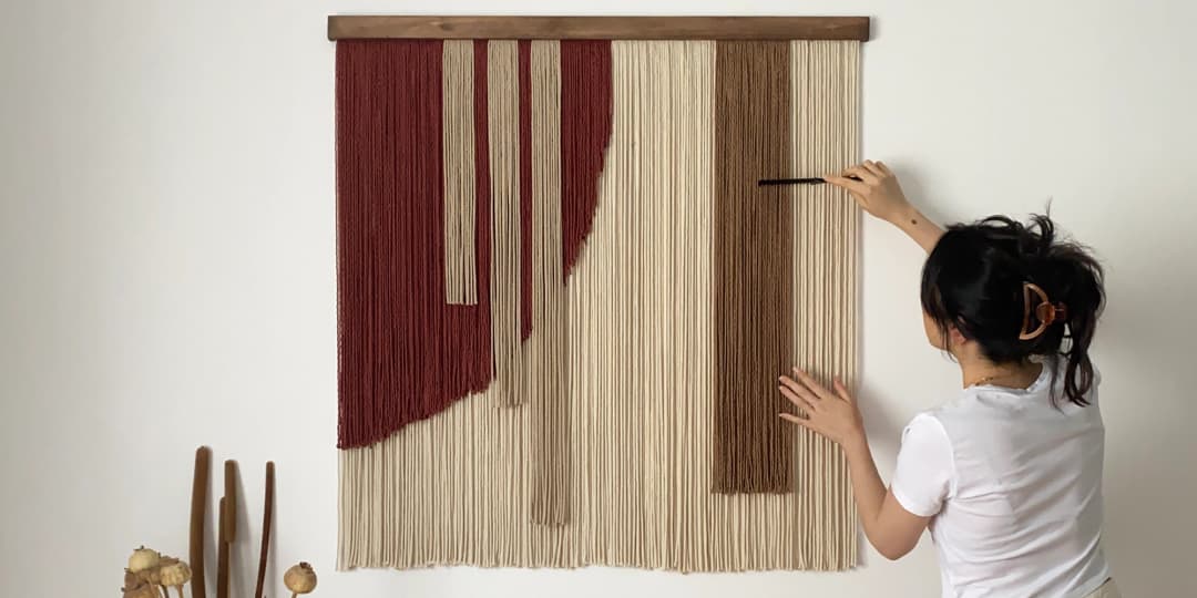 Elif straightening the yarn of her artwork, Sorrel.