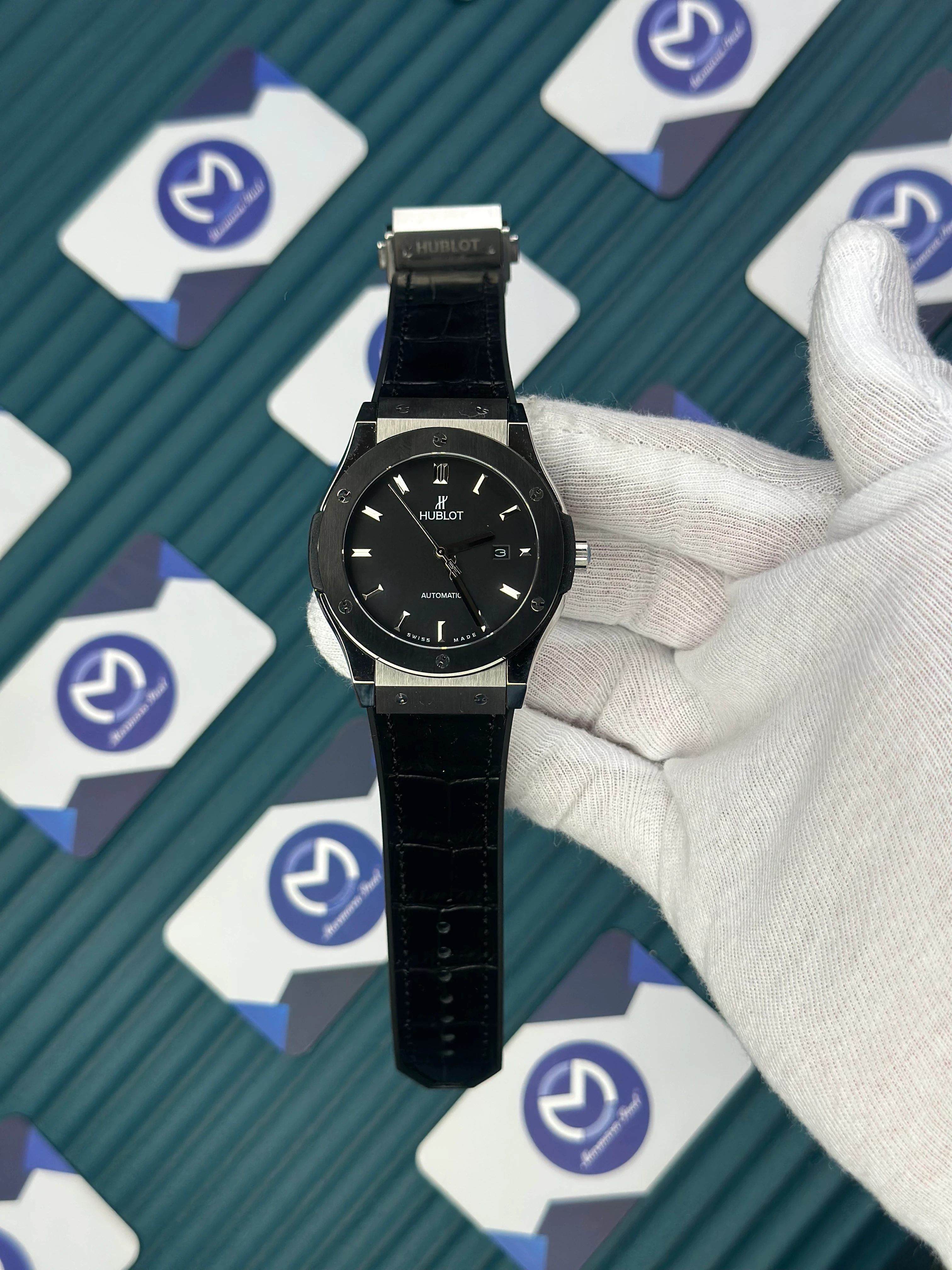 HUBLOT GENEVE AUTOMATIC BLACK DIAL SILVER CASE BLACK BEZEL BLACK LEATHER CORD 