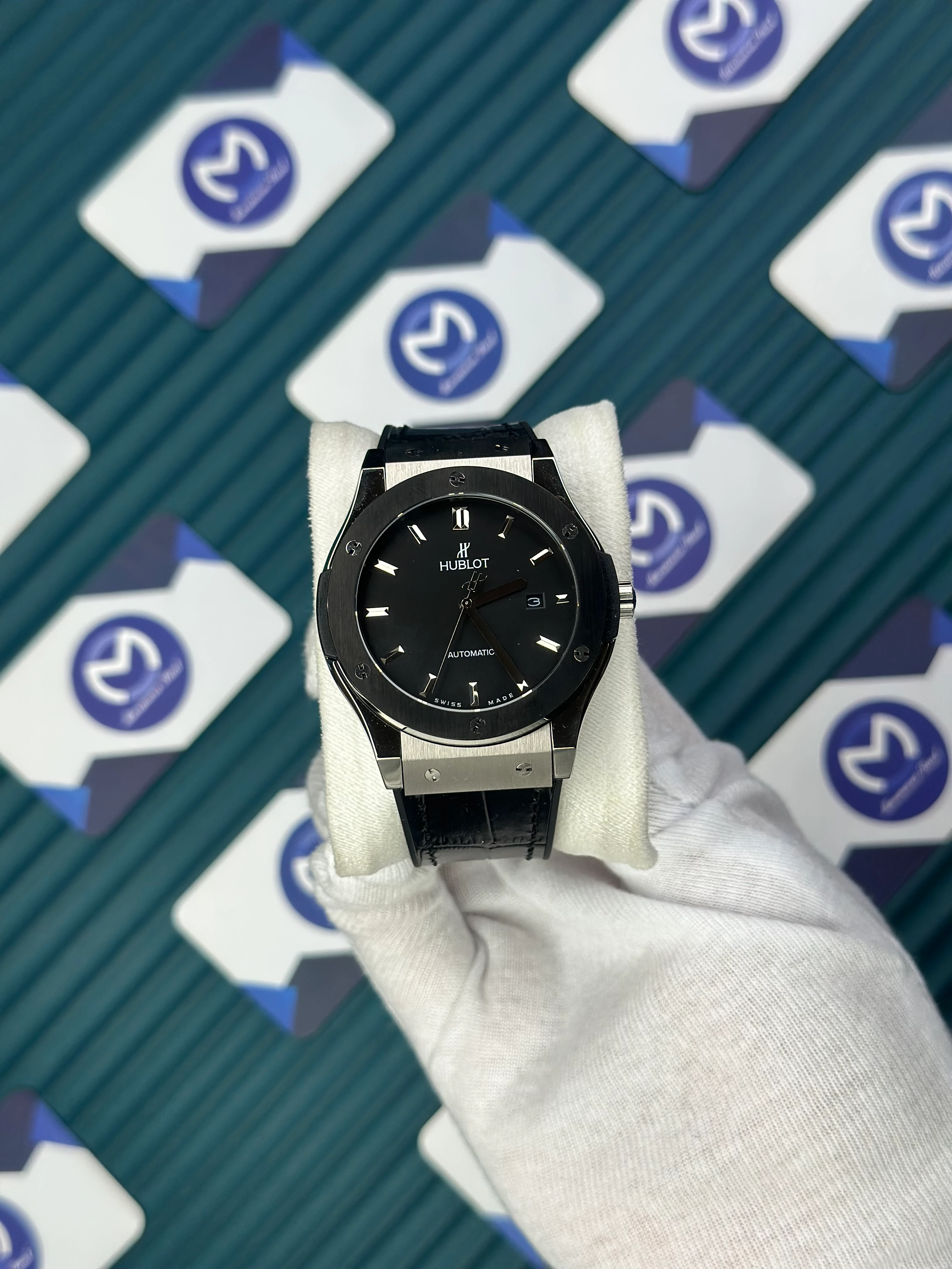 HUBLOT GENEVE AUTOMATIC BLACK DIAL SILVER CASE BLACK BEZEL BLACK LEATHER CORD 