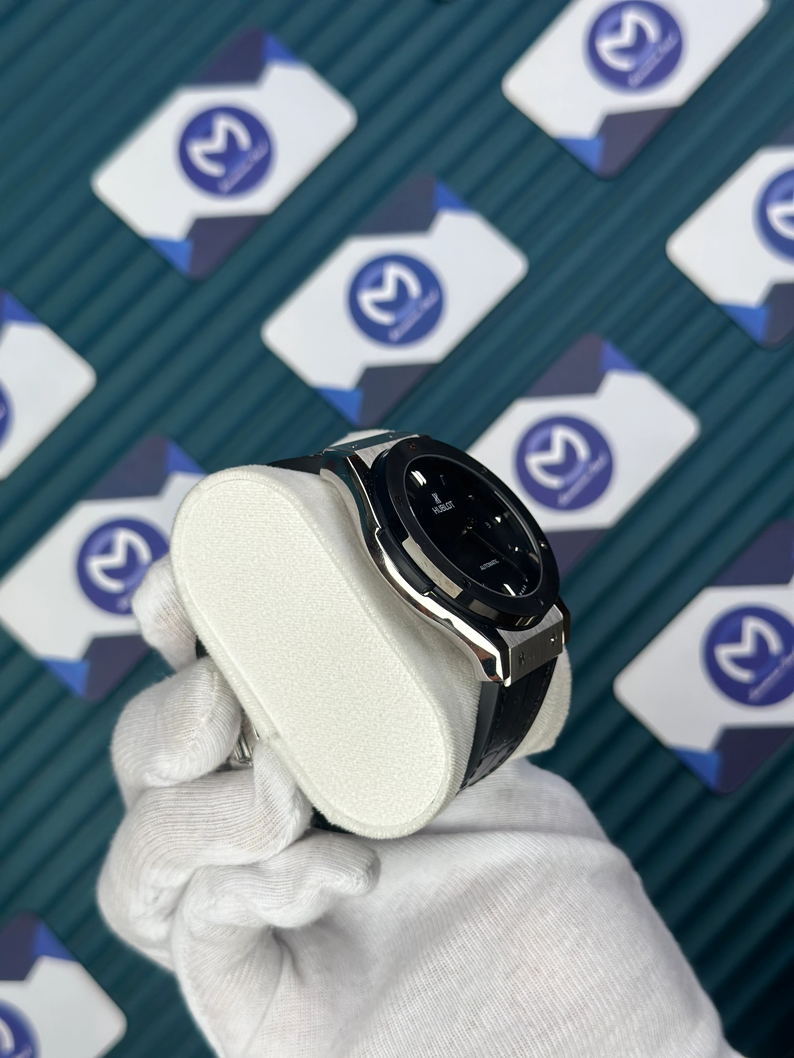 HUBLOT GENEVE AUTOMATIC BLACK DIAL SILVER CASE BLACK BEZEL BLACK LEATHER CORD 