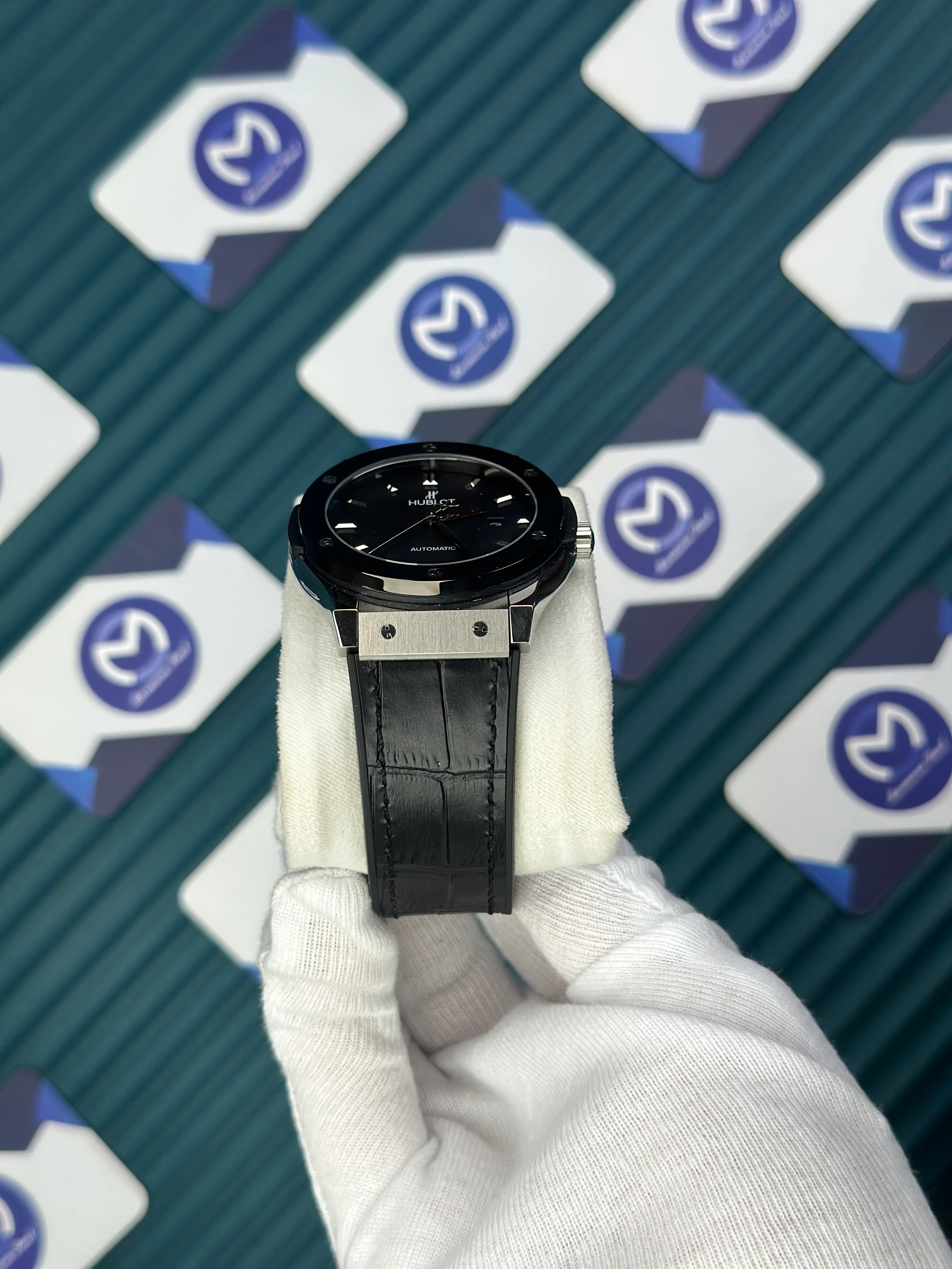 HUBLOT GENEVE AUTOMATIC BLACK DIAL SILVER CASE BLACK BEZEL BLACK LEATHER CORD 