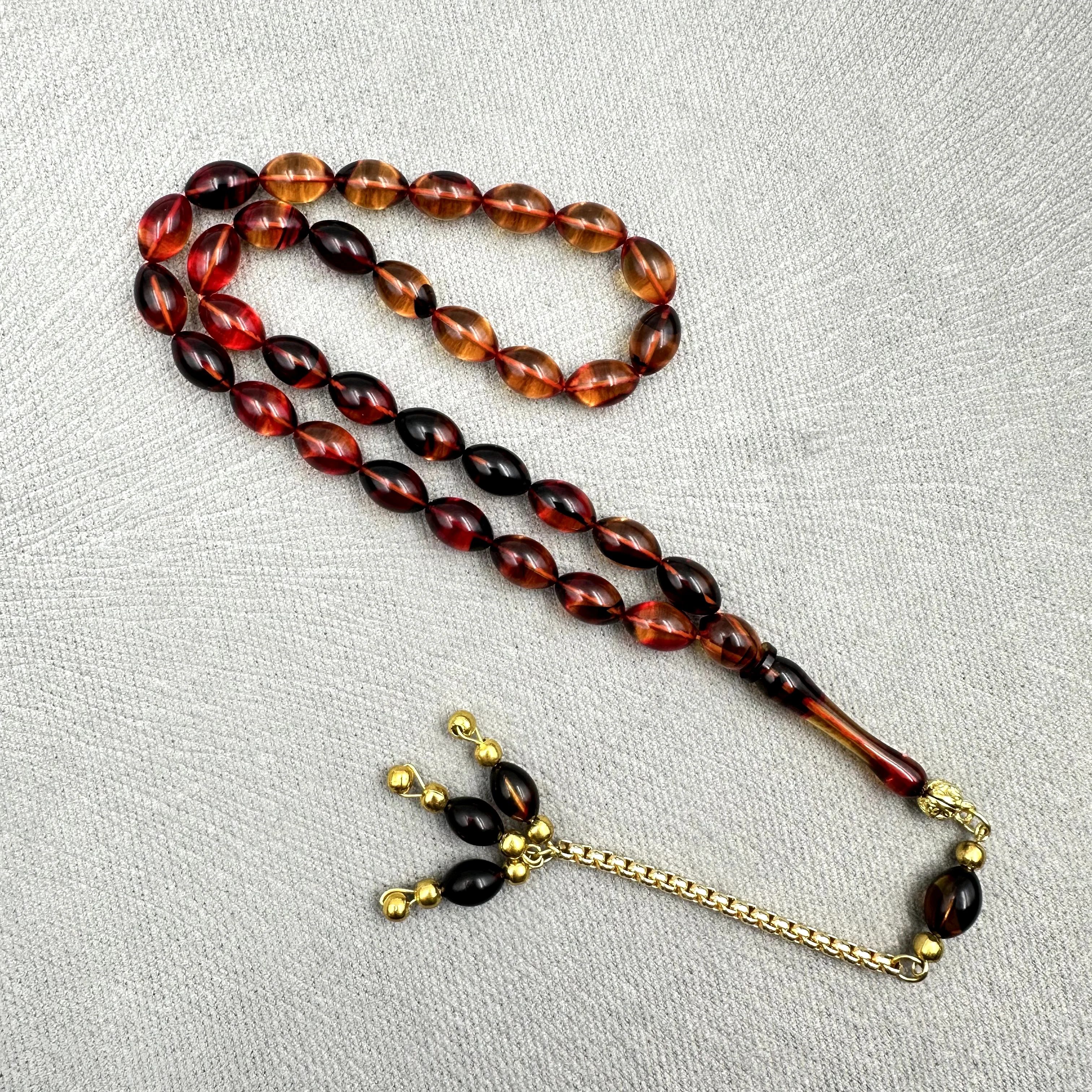 Burak Özecik Usta İşçilikli Yoğun Hare Geçişli Kırmızı Siyah Renk Altın Ton Kaplama Metal Zincir Püskül Detaylı Sıkma Kehribar Tespih