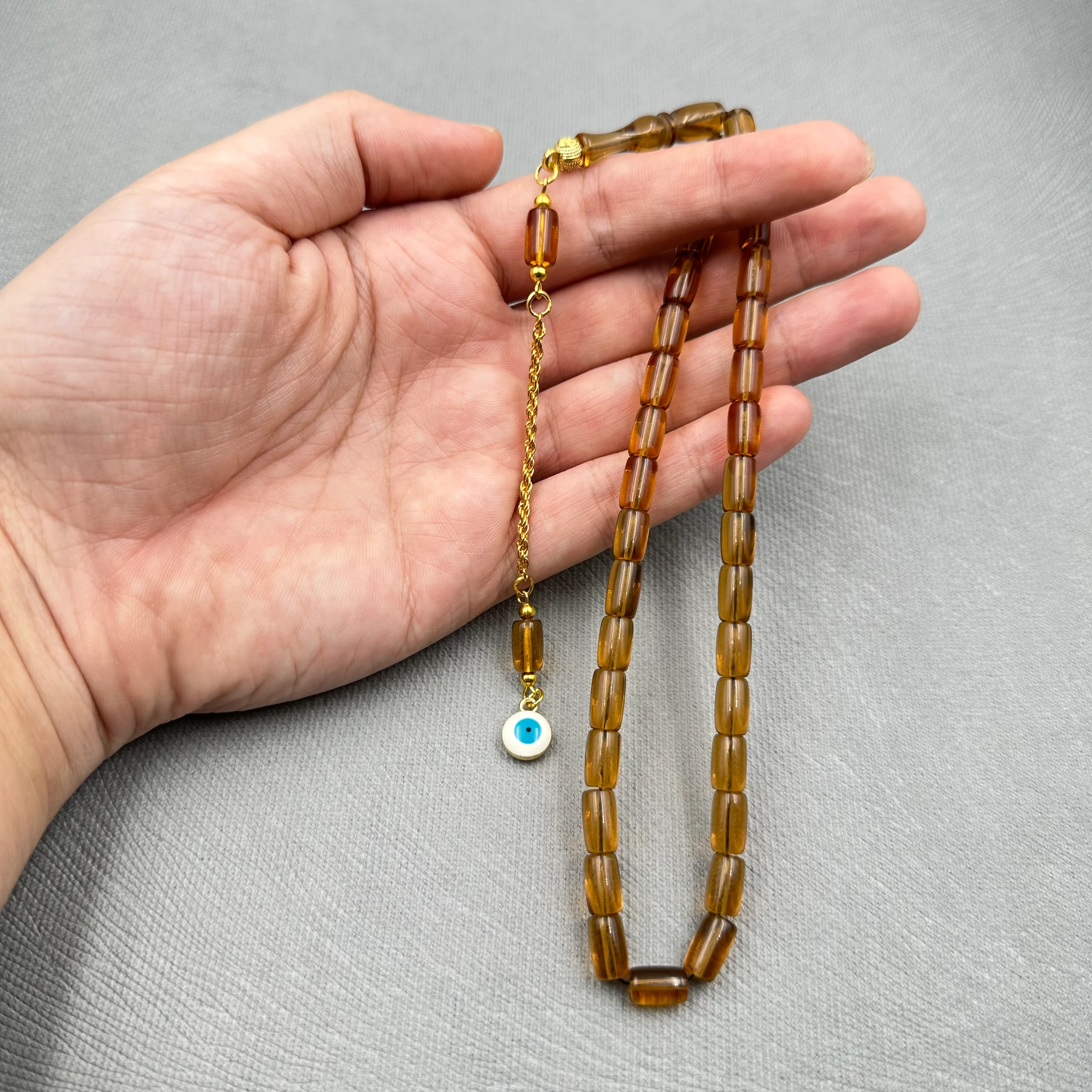 Pirinç Püsküllü Nazar Boncuğu Detaylı Bilek Boy Kapsül Kesim Bal Rengi Uçak Camı Tespih