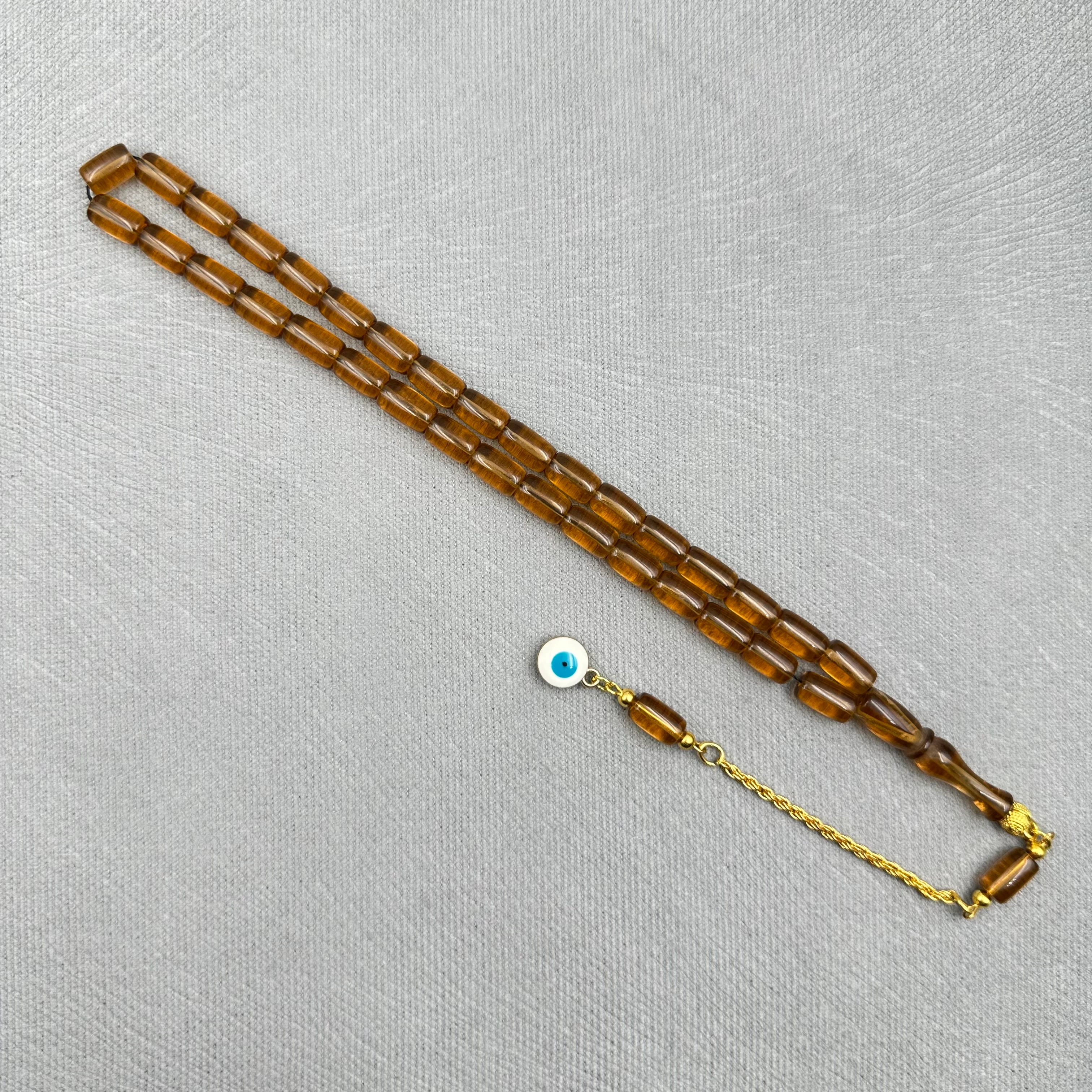 Pirinç Püsküllü Nazar Boncuğu Detaylı Bilek Boy Kapsül Kesim Bal Rengi Uçak Camı Tespih