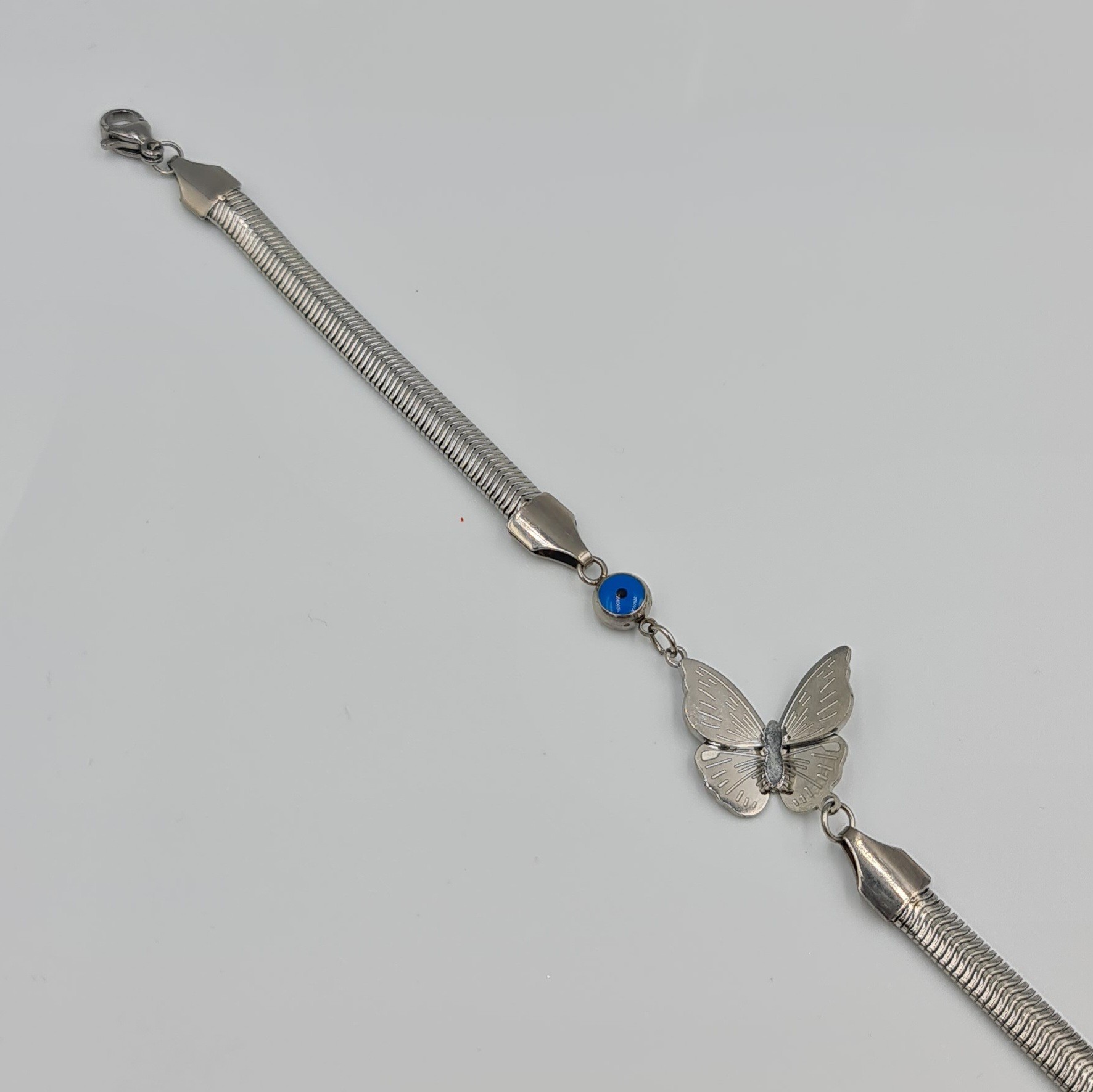 Kelebek Figürlü Gümüş Renk Çelik Bileklik – Nazar Detaylı, Ayarlanabilir Uzunluk (19+6 cm, 5 mm Zincir)
