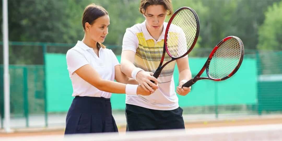 “HEAD raketleriyle kortta tenis oynayan çift”