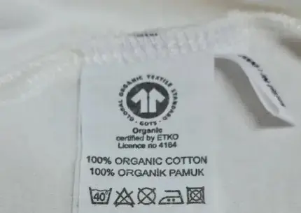 Gerçek bir organik ürün etiketi. GOTS logosu var, kimin tarafından onaylandığı ve üretici lisans numarası yazıyor, içerik de açık şekilde belirtiliyor.&nbsp;