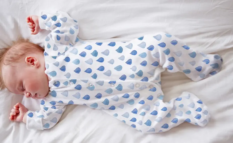 %100 Organik pamuk, Ozmoz Clean&Safe tulumu içinde huzurla ve güvenle uyuyan bir bebek.