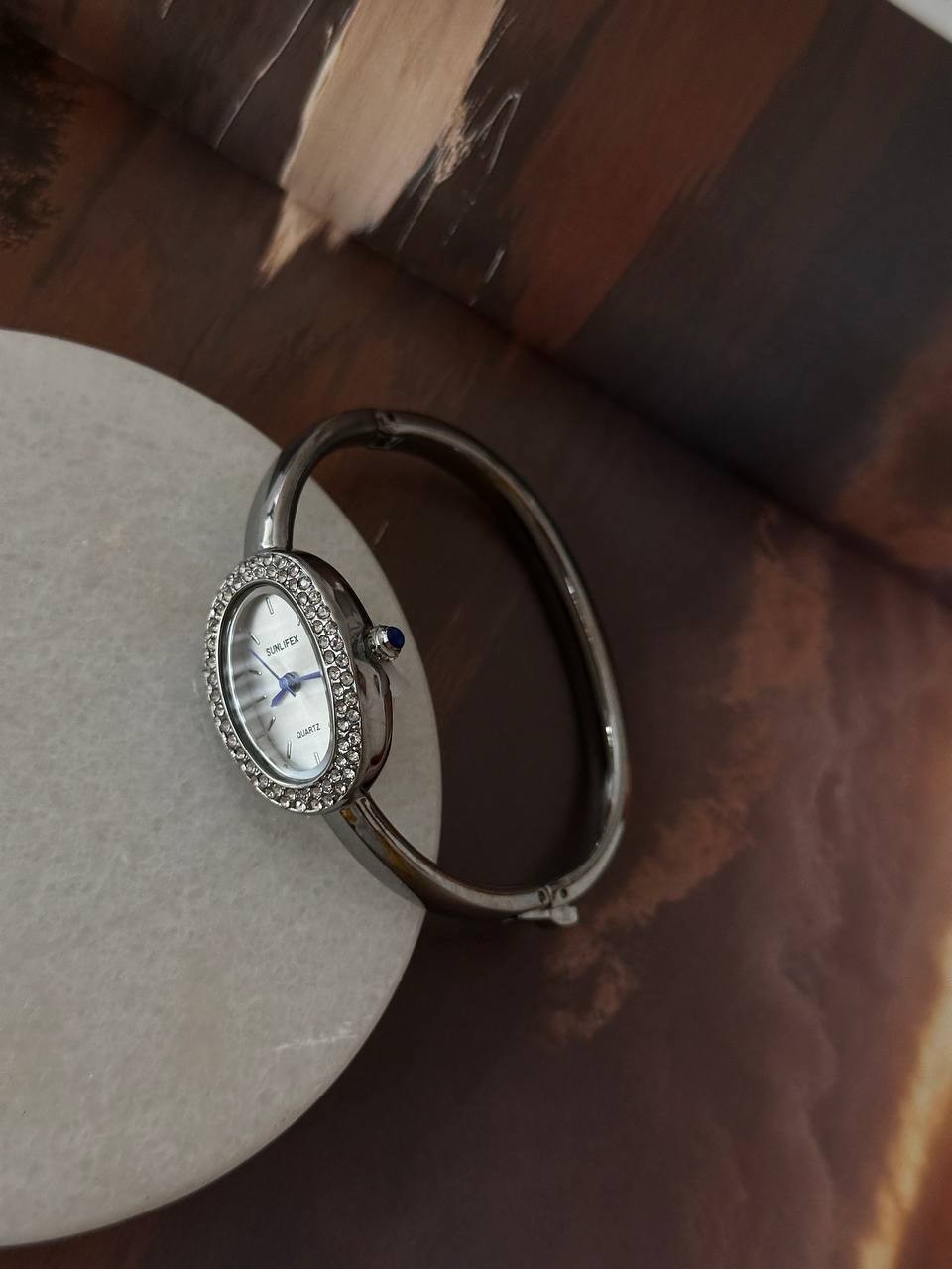 Paslanmaz Çelik Gümüş Renk Kristal Taşlı Beyaz Kadranlı Kelepçe Model Kadın Kol Saati Genişlik 5,5 cm.
