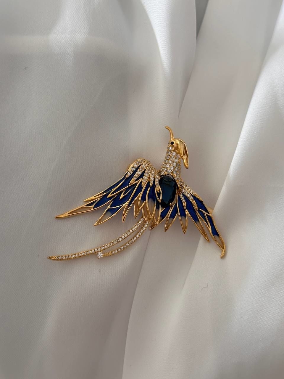 Gold Renk Zirkon Beyaz ve Mavi Taşlı Anka Kuşu Figürlü Broş Genişlik 6,5 cm. Boy 6 cm.