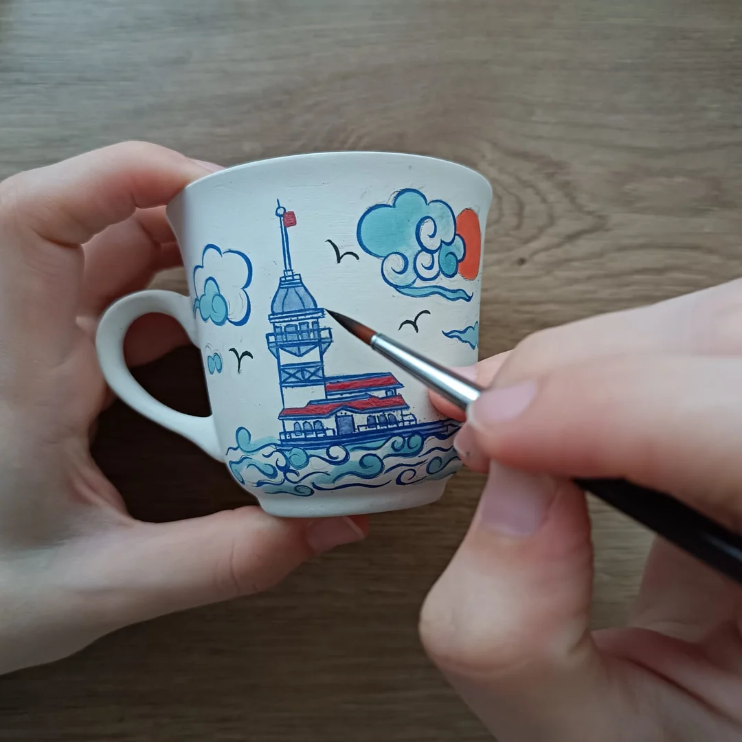 Sanatçımız Zeynep Ergül Kız Kulesi Fincanını elde dekorlarken..