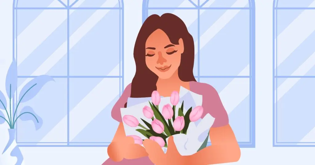 Kendi kendine Sevgililer Günü hediyesi olarak aldığı pembe lale buketini koklayan mutlu kadın.