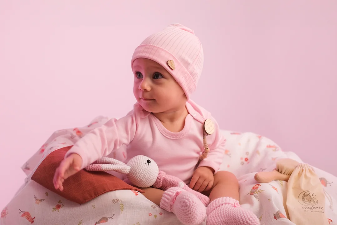 Pembe kıyafetli bebek mutlu ve tatlı bir şekilde bakıyor