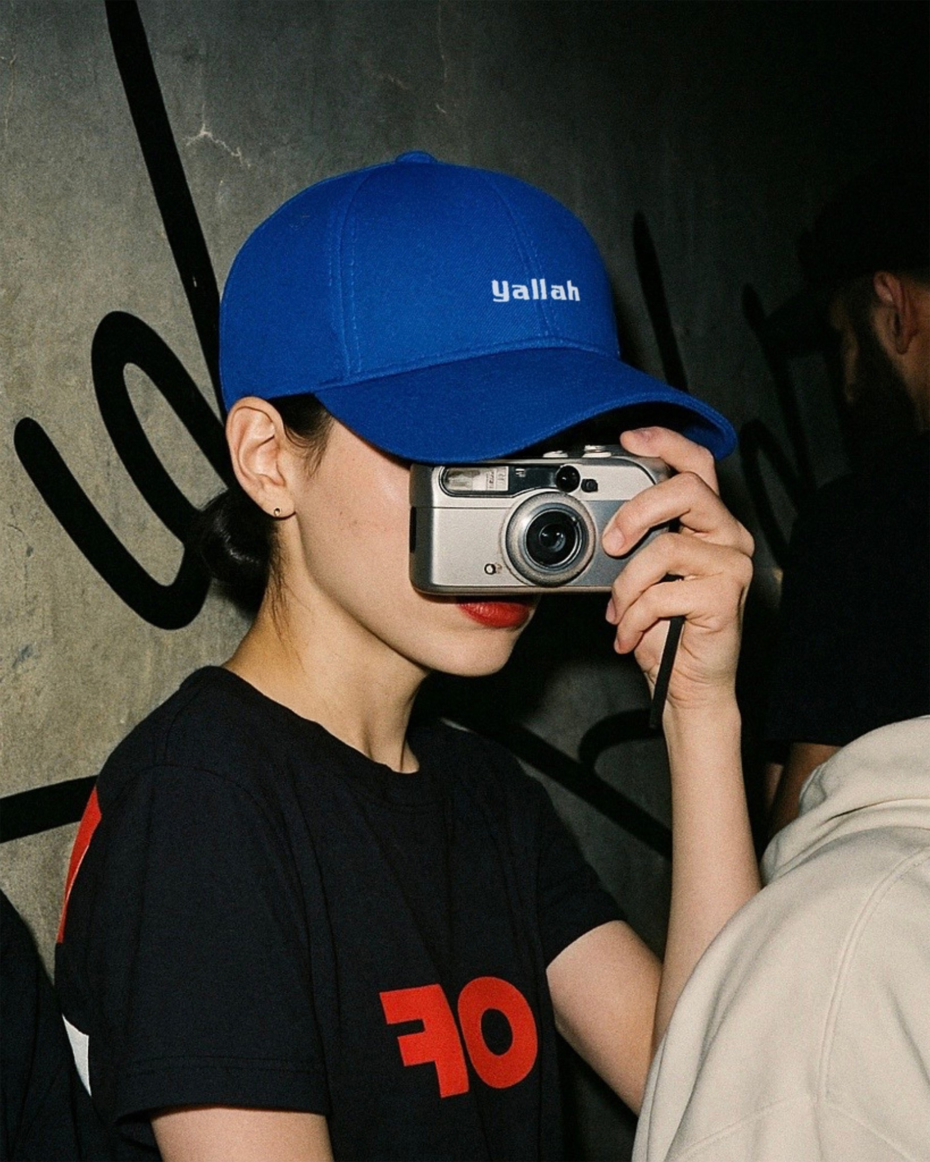 she wears yallah baseball cap and taking picture