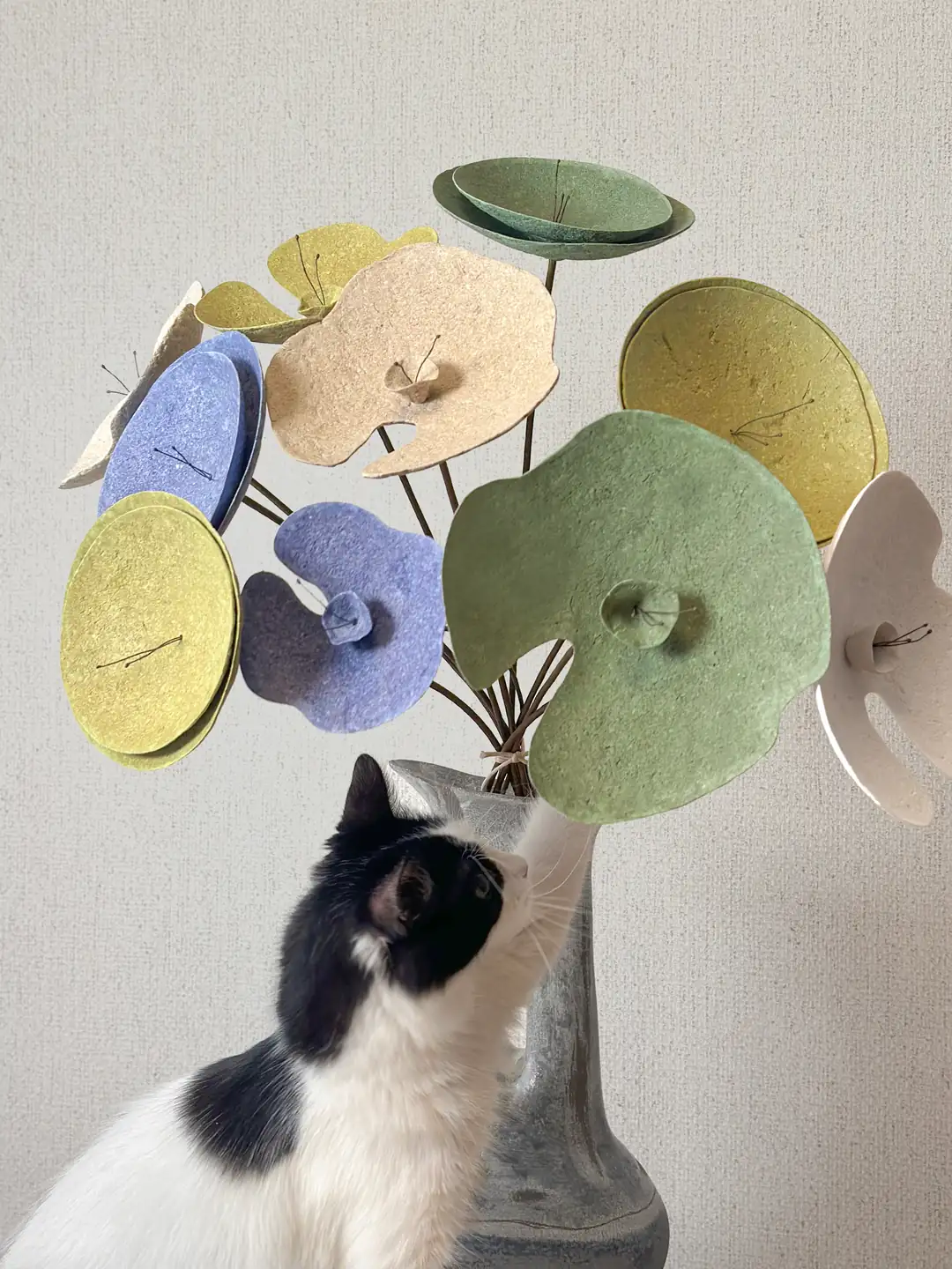 Renkli upcycled çiçek aranjmanı, oturma odası dekorasyonunda meraklı bir kediyle eğlenceli kompozisyon.